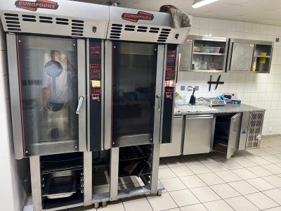 a commercial kitchen with stainless steel appliances and tile flooring