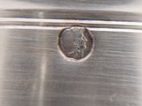 a close up of a piece of metal with a coin on it