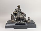 une image représentant la statue d'un homme assis sur une table