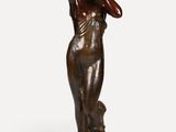 une statue en bronze représentant une femme, les mains posées sur la tête