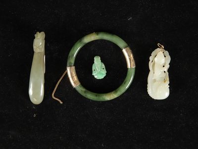 three pieces of jade and jade jade jewelry on a black surface
