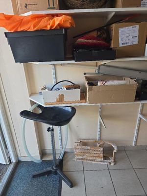 un tabouret noir posé devant une étagère remplie de cartons