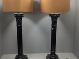 pair of black lamps with beige shades on a white table