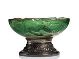 un saladier en verre vert posé sur un support en métal