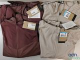 trois paires de pantalons pour homme, encore étiquetés, posées sur une table