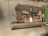 Plusieurs morceaux de bois sont empilés sur des palettes dans un garage