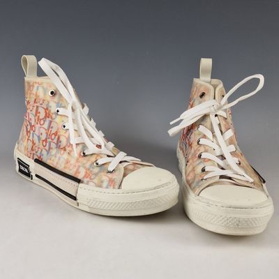 une paire de baskets ornées de graffitis sur fond gris