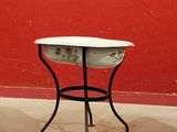 une petite table sur laquelle est posé un bol, devant un mur rouge