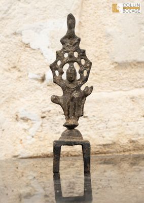 un petit objet métallique posé sur une table devant un mur