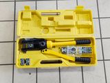 une boîte à outils jaune contenant des outils, posée sur un sol carrelé