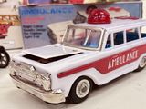 a toy ambulance and a toy car next to each other