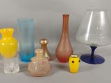 de nombreux vases de différentes couleurs posés sur une surface blanche