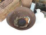 a brown bowl sitting on top of a table next to a white vase