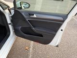 a white car with the door open in a parking lot