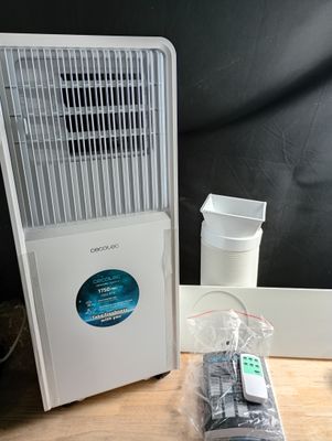 a small air conditioner sitting on a table next to a remote control
