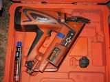 an orange box with a stapler, glue gun, and other tools in it