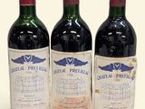 three bottles of red wine sitting next to each other on a white surface