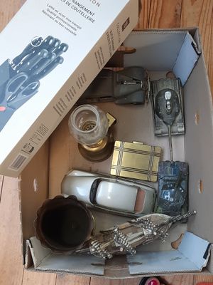 une boîte remplie d'objets hétéroclites posée sur le sol
