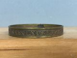 a close up of a gold ring on a wooden table