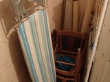 une table à repasser et une chaise dans une petite pièce