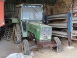 a green tractor that is parked in a barn