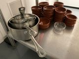 many pots and pans sitting on a metal table