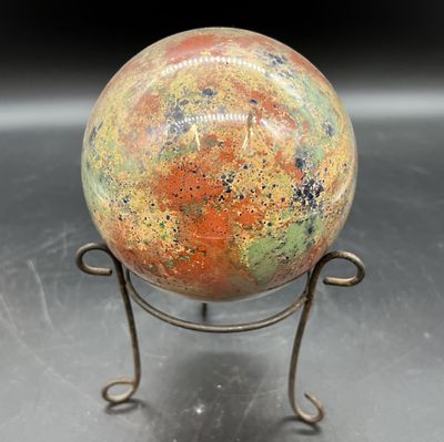 une image représentant une boule de verre colorée posée sur un socle