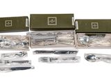 a lot of silverware in a box on a white surface