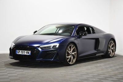 une voiture de sport Audi bleue garée dans une pièce au sol à carreaux