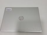 the laptop is sitting on a white table with a small sticker on the back of it