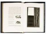 an open book with a black and white picture of a door