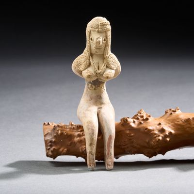 une image représentant une statue d'une femme assise sur un morceau de bois