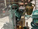 many vases and bowls on display in a glass case