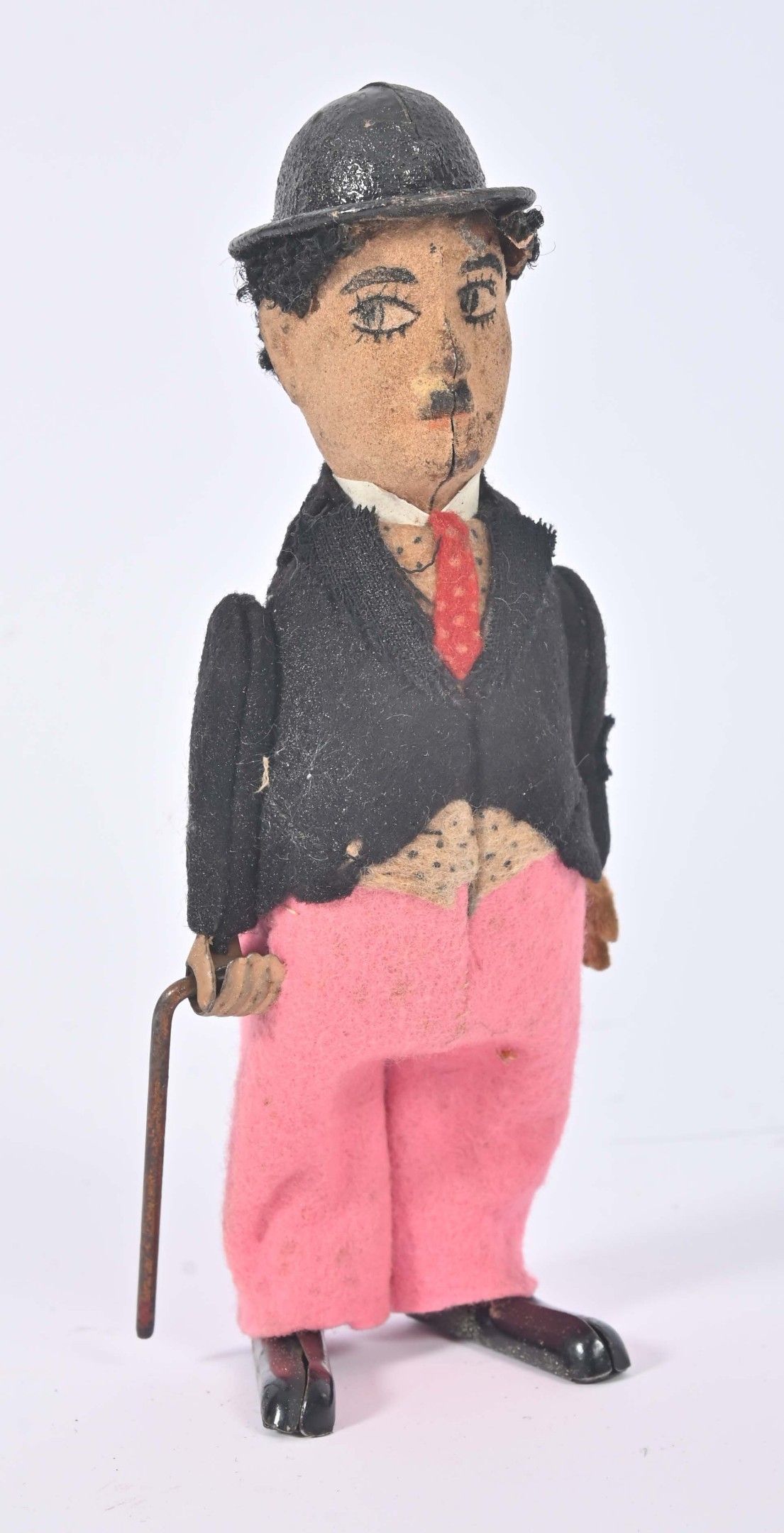 Schuco, Charlie Chaplin dit Charlot Jouet mécanique en habits de feutrine avec pantalon rose, la canne tourne à toute...