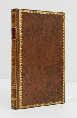 un livre en cuir marron avec des finitions dorées, y compris sur la couverture