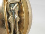 a gold ball with a figurine of a woman inside of it