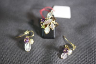two pairs of earrings and a ring on a table