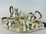 a silver tea set on a silver tray on a table