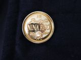 a close up of a gold coin on a black jacket