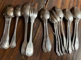 six spoons and six forks on a wooden table