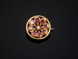a close up of a gold ring with pink stones on a black surface