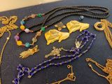 many different necklaces and bracelets that are on a table