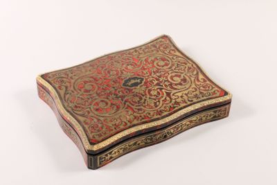 an old box with a decorative design on it on a white surface