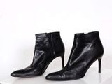 pair of black leather high heeled boots on a white surface