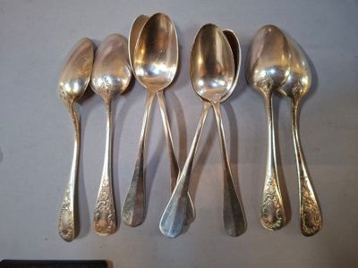 six cuillères en argent sont alignées sur une table