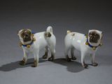 pair of porcelain figurines of two dogs with bells on their necks