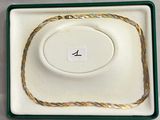 un gros plan sur un collier en or posé dans un écrin sur une table