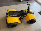 a small yellow motorcycle parked on the floor in a showroom