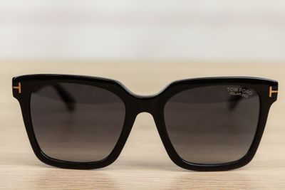 a pair of black sunglasses sitting on top of a wooden table