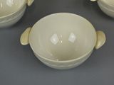 three bowls and a bowl with handles on a table